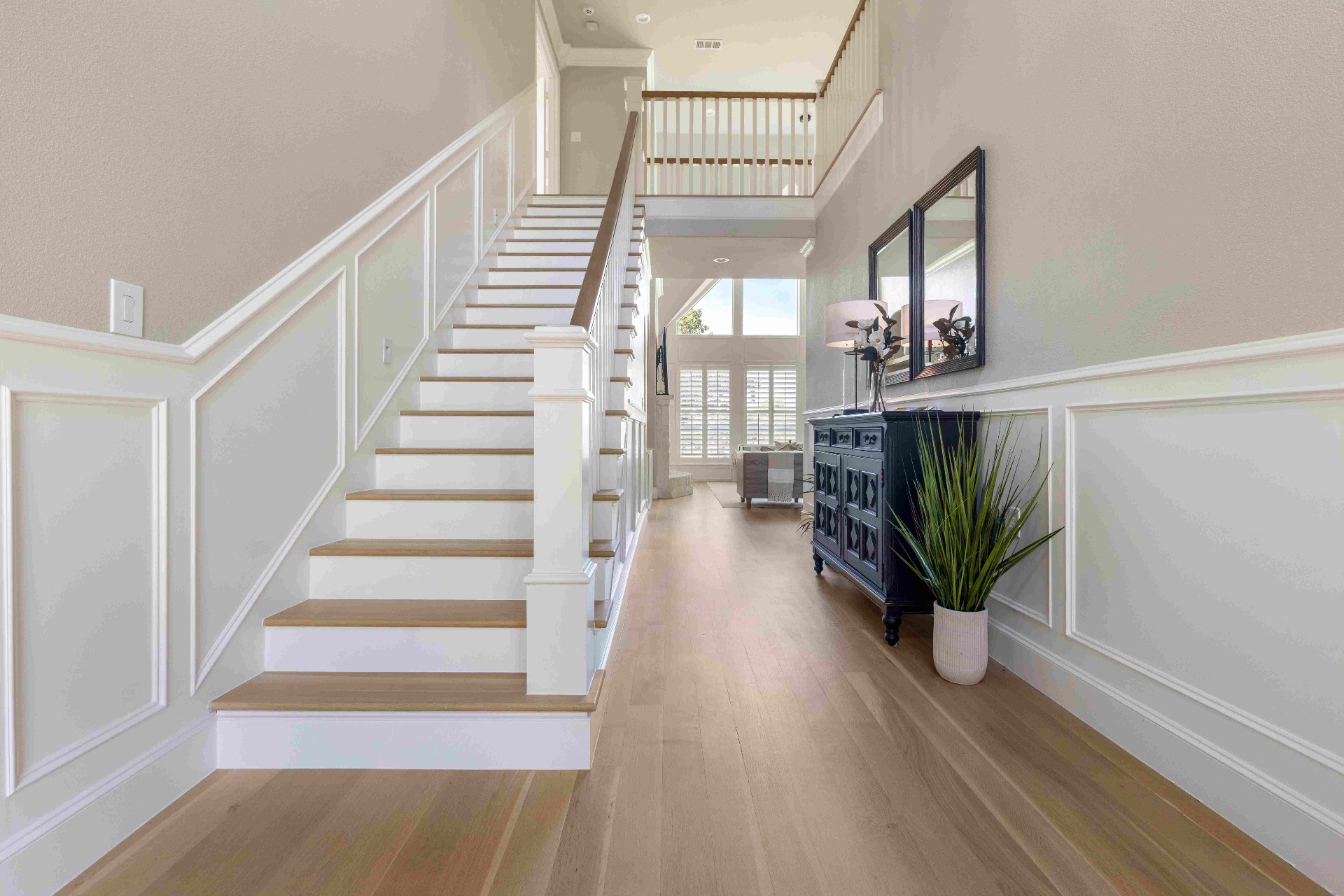 Two-story foyer with wainscoted staircase and white oak treads