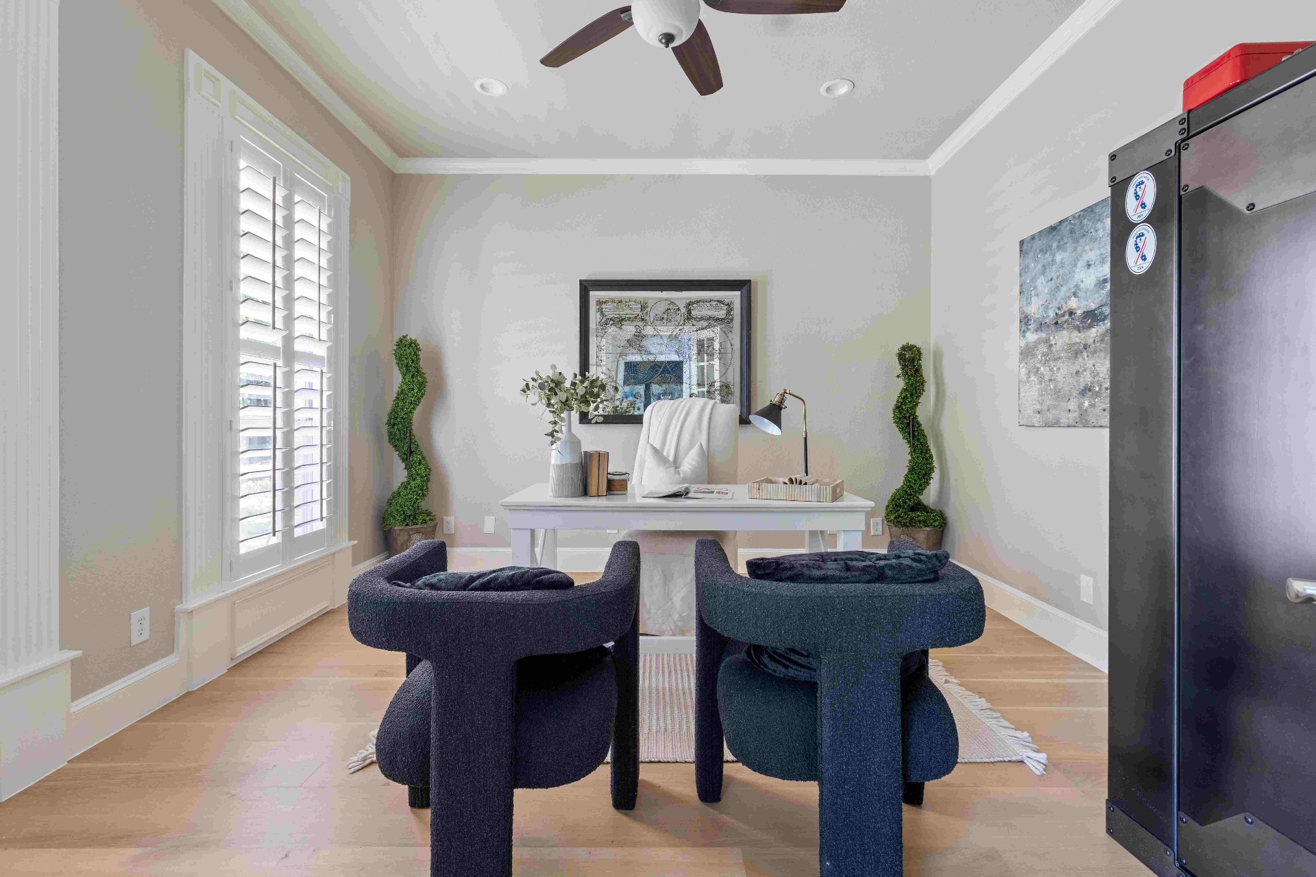Private study with plantation shutters, ceiling fan, and hardwood floors
