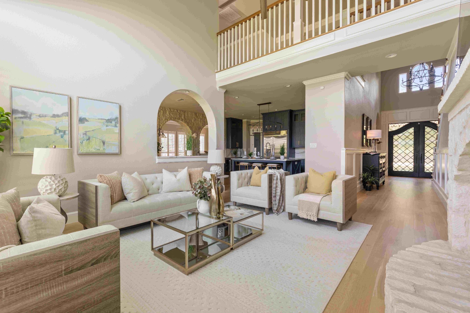 Two-story living room with stone fireplace opening to kitchen