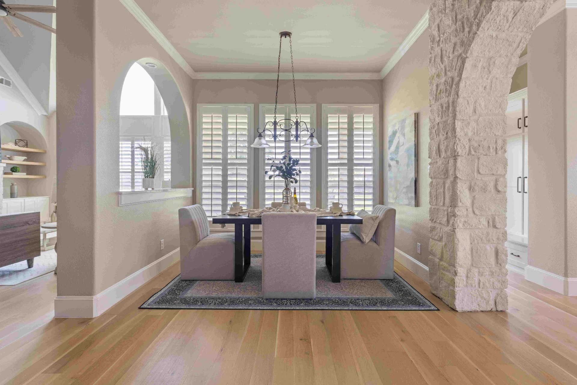 Formal dining room with stone archway and plantation shutters