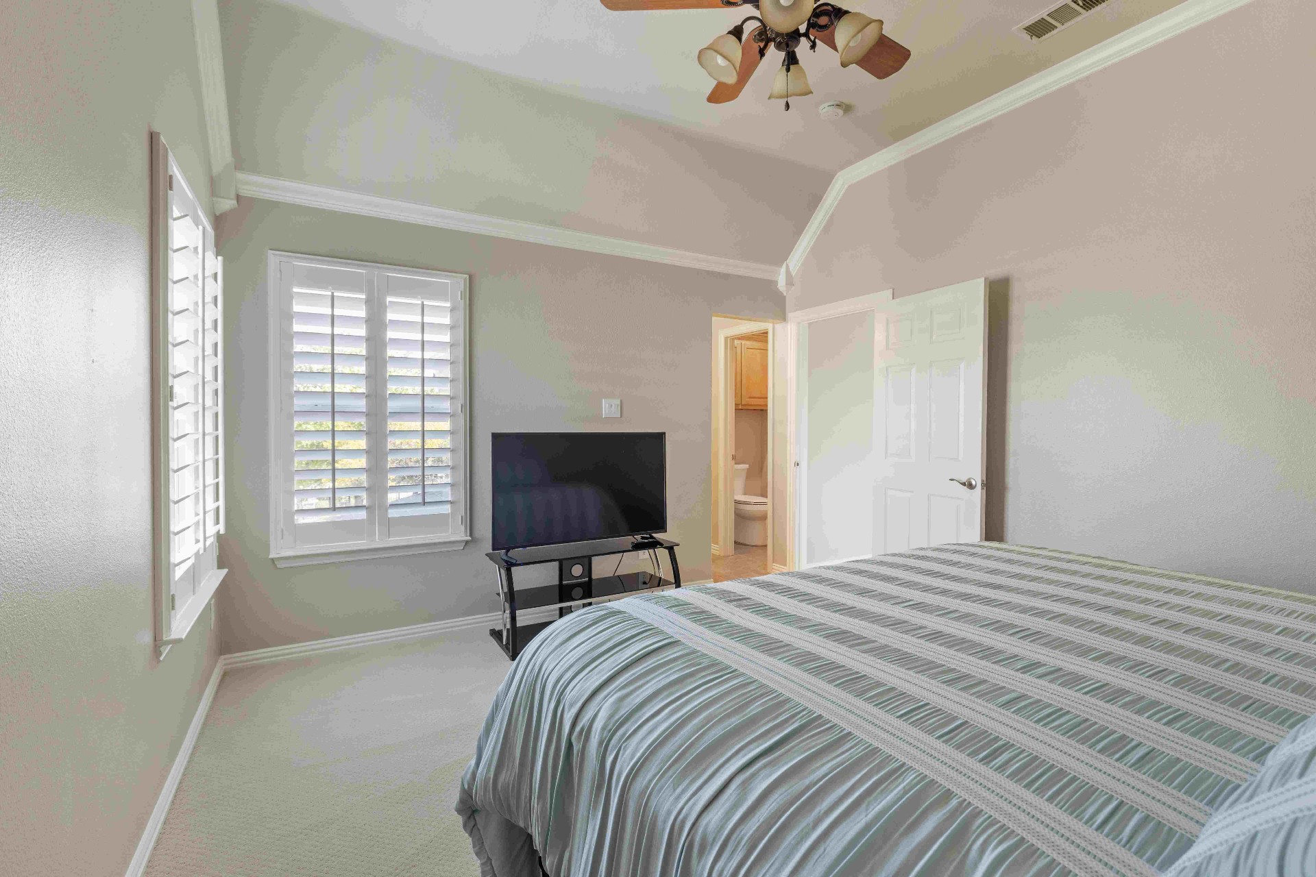 Secondary bedroom with vaulted ceiling and private ensuite bath