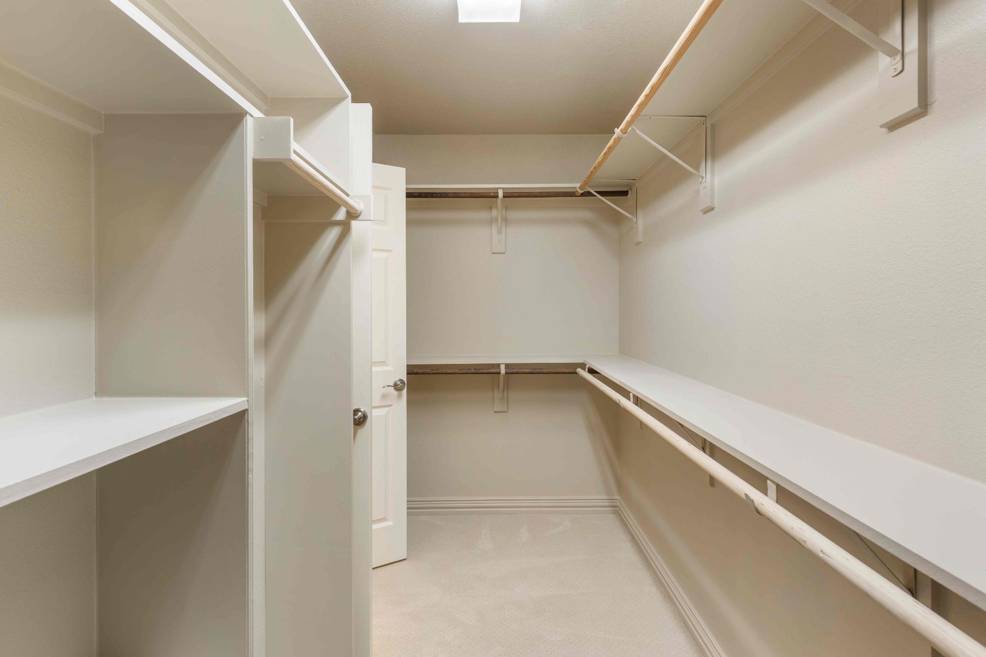 Spacious secondary walk-in closet with built-in shelving and dual hanging rods